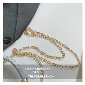 Detail of the golden metal chain strap on a shimmering silver sequin evening clutch bag