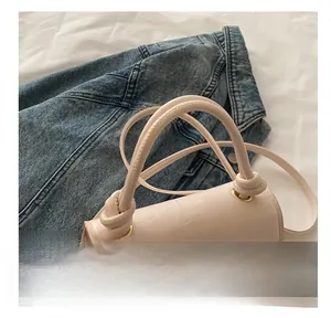 Gros plan du sac à main en cuir beige à motif crocodile avec poignée nouée élégante