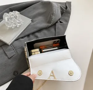 Silver handbag interior storage showing capacity for smartphone, lipstick, and cosmetics