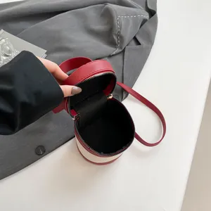 Contrast color bucket bag with red and white stitching and secure zipper closure