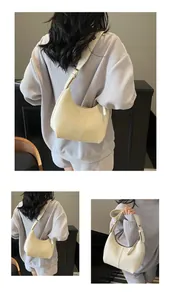 Detail view of the cream hobo bag showing the wide strap and soft leather texture