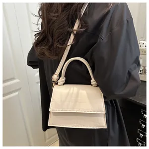 Détail du sac à main crème en similicuir crocodile avec poignée tissée et métal doré