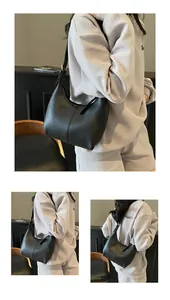 Close-up of black matte PU leather hobo bag with half-moon shape and vertical stitching