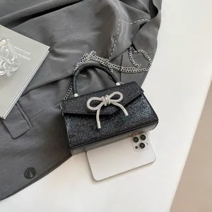 Sparkly black sequin crossbody bag with silver rhinestone bow and chain strap