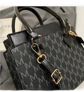 Detail of vintage monogram shoulder bag with gold hardware and M letter print