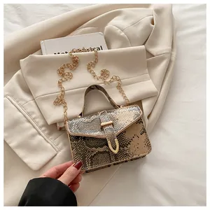 Detail of snake print texture on crossbody bag with gold chain and U-shaped metal buckle
