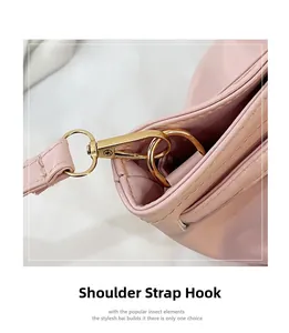 Detail of metal shoulder strap hook and D-ring on pink leather crossbody bag