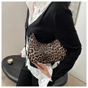 Λεπτομέρεια της vintage hobo τσάντας με λεοπάρ σχέδιο φορεμένη στον ώμο για ρετρό στυλ