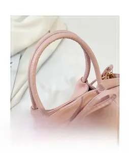 Close-up of pink fashion handbag featuring smooth round handles and fine stitching details