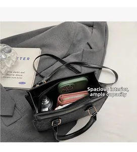 Macro shot of spacious interior of retro monogram tote bag holding phone and wallet