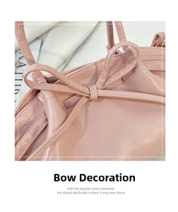 Detailed view of pink leather handbag with a feminine ribbon bow and stitching