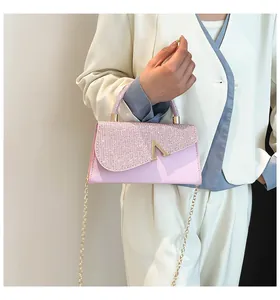 Detail of elegant pink rhinestone handbag with gold V-metal clasp and chain strap
