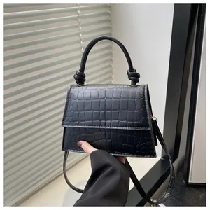 Détail de la texture en cuir PU croco noir et de la poignée avec nœud décoratif