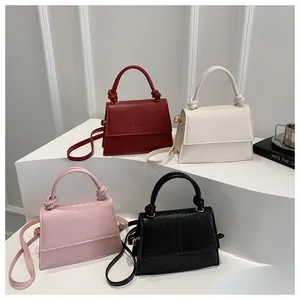 Quatre mini sacs à bandoulière en bordeaux, blanc, rose et noir avec motif crocodile