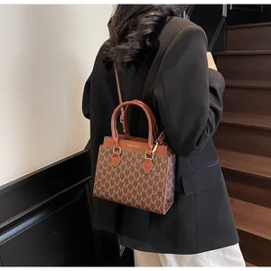 Detailed back view of vintage brown monogram handbag with adjustable shoulder strap