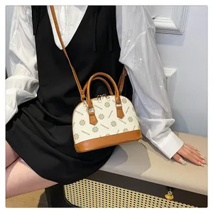 Nahaufnahme der beige Muscheltasche mit Vintage-Monogramm und braunem Ledergriff