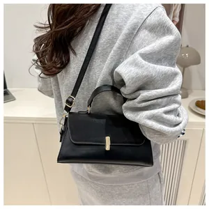 Détails du sac bandoulière noir minimaliste avec boucle dorée et sangle réglable