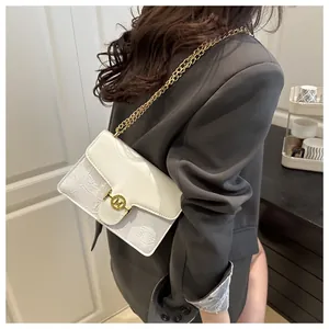 Dettaglio borsa bianca in pelle con goffratura floreale e catena dorata logo M