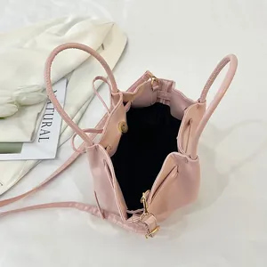 Pale pink faux leather trapezoid bag with dual handles and inner magnetic closure