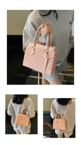 Detail of pink monogram handbag with leather handles and metallic fashion logo