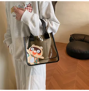 Gros plan du sac cosmétique en PVC transparent avec motif dessin animé et anses noires