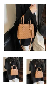 Detail view of brown printed handbag with adjustable shoulder strap and gold logo