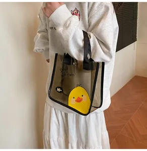 Detalle del bolso tote de PVC gris traslúcido con un lindo estampado de pato amarillo