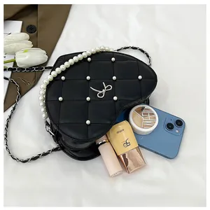 Internal storage of heart-shaped pearl bag holding phone and lipstick cosmetics