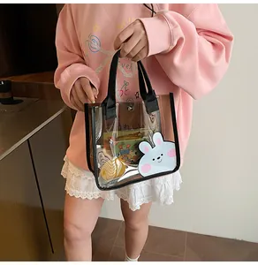 Dettaglio di una borsa trasparente in PVC con stampa a coniglio e manici in tessuto nero