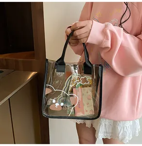 Detalle de un bolso tote de PVC transparente marrón con oso de dibujos y asas negras
