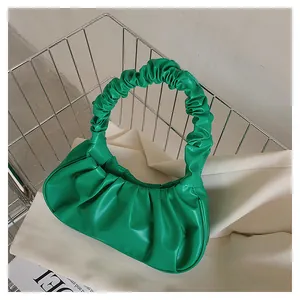 Nahaufnahme der hellgrünen Rafftasche aus glänzendem Kunstleder in Wolkenoptik