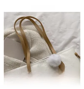 Détail du sac cabas blanc gaufré avec bandoulières en cuir marron et pompon doux