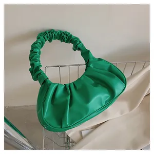 Detailansicht der grünen Cloud-Bag aus Kunstleder mit Falten in einem Metallkorb
