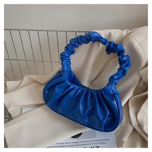 Detail der königsblauen Rafftasche mit PU-Lederstruktur auf einem beigen Blazer