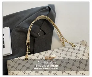 Detalle de la cómoda correa de hombro con cadena dorada en un bolso tote monograma