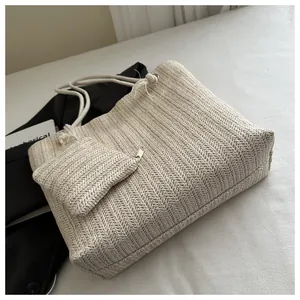 Detail van beige strooien draagtas met visgraatweefpatroon en bijpassend klein tasje erbij
