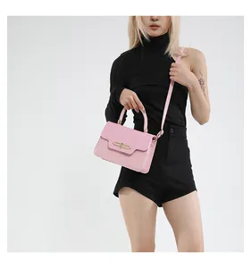 Detail of pink crossbody bag featuring woven texture flap and golden metal buckle clasp