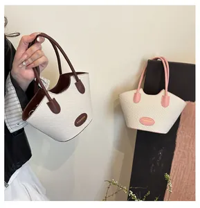 Detail von gewebten Mini-Tragetaschen in Braun und Pink mit modischen Markenschildern