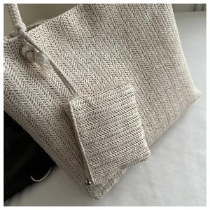 Detailweergave van beige strooien shopper-textuur met bijpassende kleine ritszak aan touw