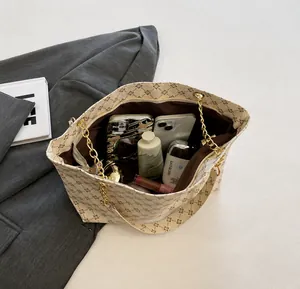 Vista superior de bolso tote vintage con cadena que muestra espacio para cosméticos