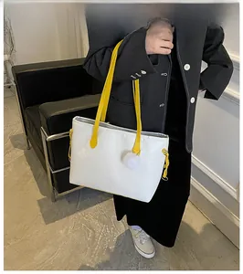 Sac cabas blanc en cuir gaufré avec anses jaunes et détail de boule en peluche