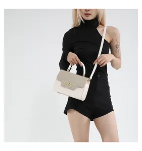 Detail of a chic two-tone crossbody bag with straw flap and golden buckle on model