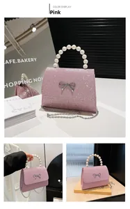 Detail der rosa Glitzertasche mit Perlengriff, Silberschleife und Metallkette