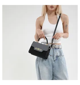 Detail of a chic two-tone crossbody bag with elegant gold metal buckle and woven texture