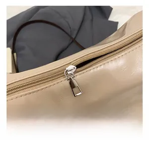 Makroaufnahme des hochwertigen silbernen Metallreißverschlusses an einer beigen Tasche
