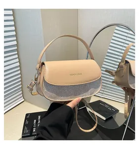 Detail of beige semicircular handbag with silver glitter sequins and fashion text