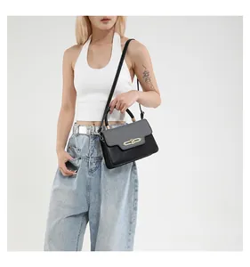 Detail of color-block crossbody bag with gold oval lock shown on model in white studio