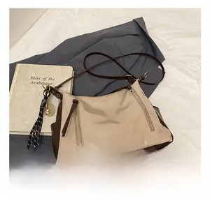 Detail der Vintage-Tote Bag in Beige und Braun mit Reißverschlüssen und Fransenanhänger