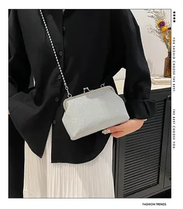 Close-up of silver glitter evening bag with pearl handle and metal clasp closure