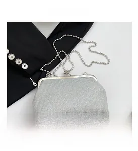 Detail of silver sequin evening bag with metal clasp and detachable beaded chain strap